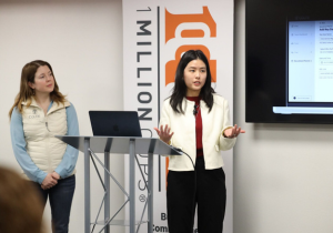 Photo of me doing presentation with a banner at the back that says 1 million